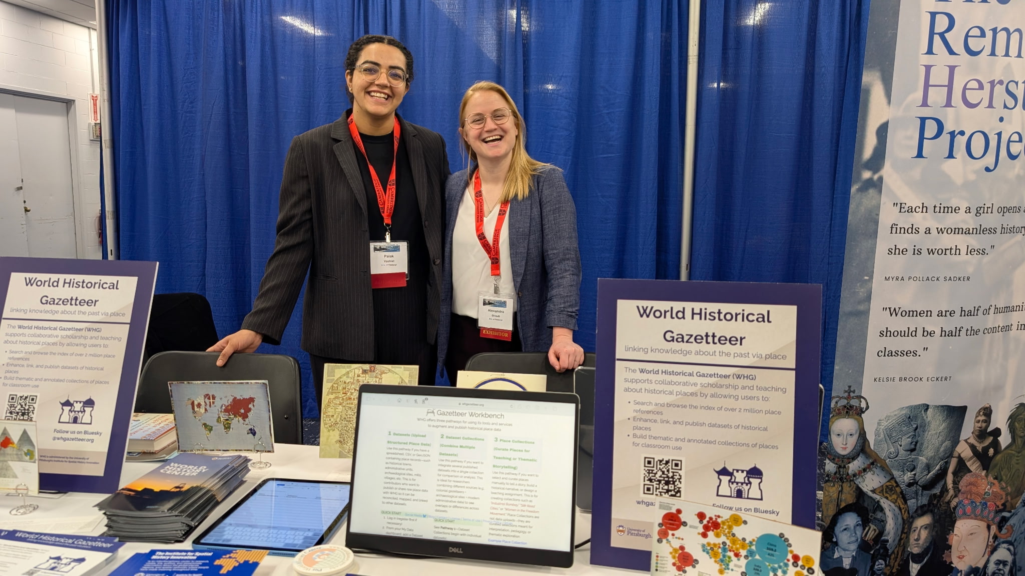 two people standing in front of exhibit table